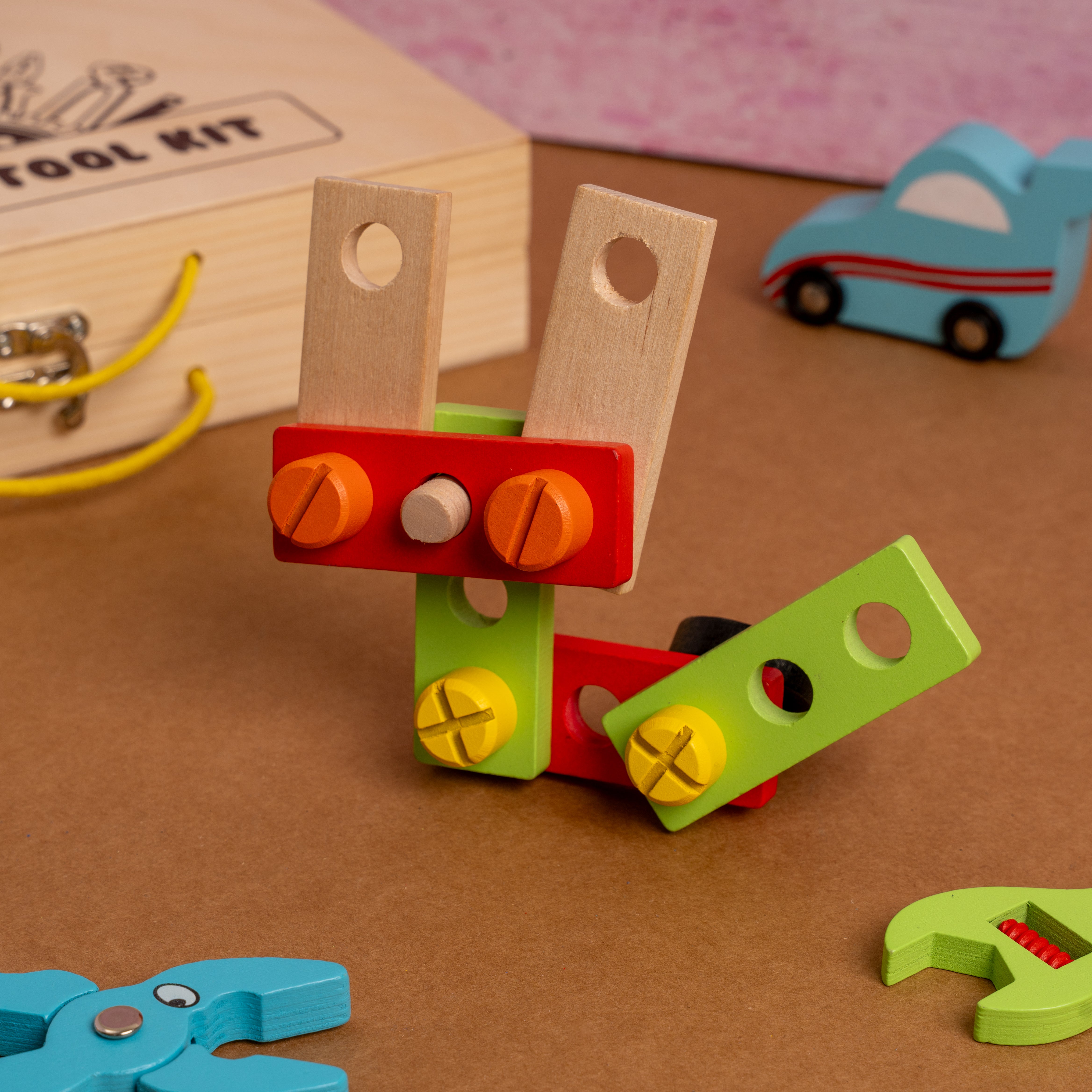 NESTA TOYS – Wooden Construction Tool Kit Toy for Kids Colorful toy tool set with a wooden toolbox and car toy in the background
