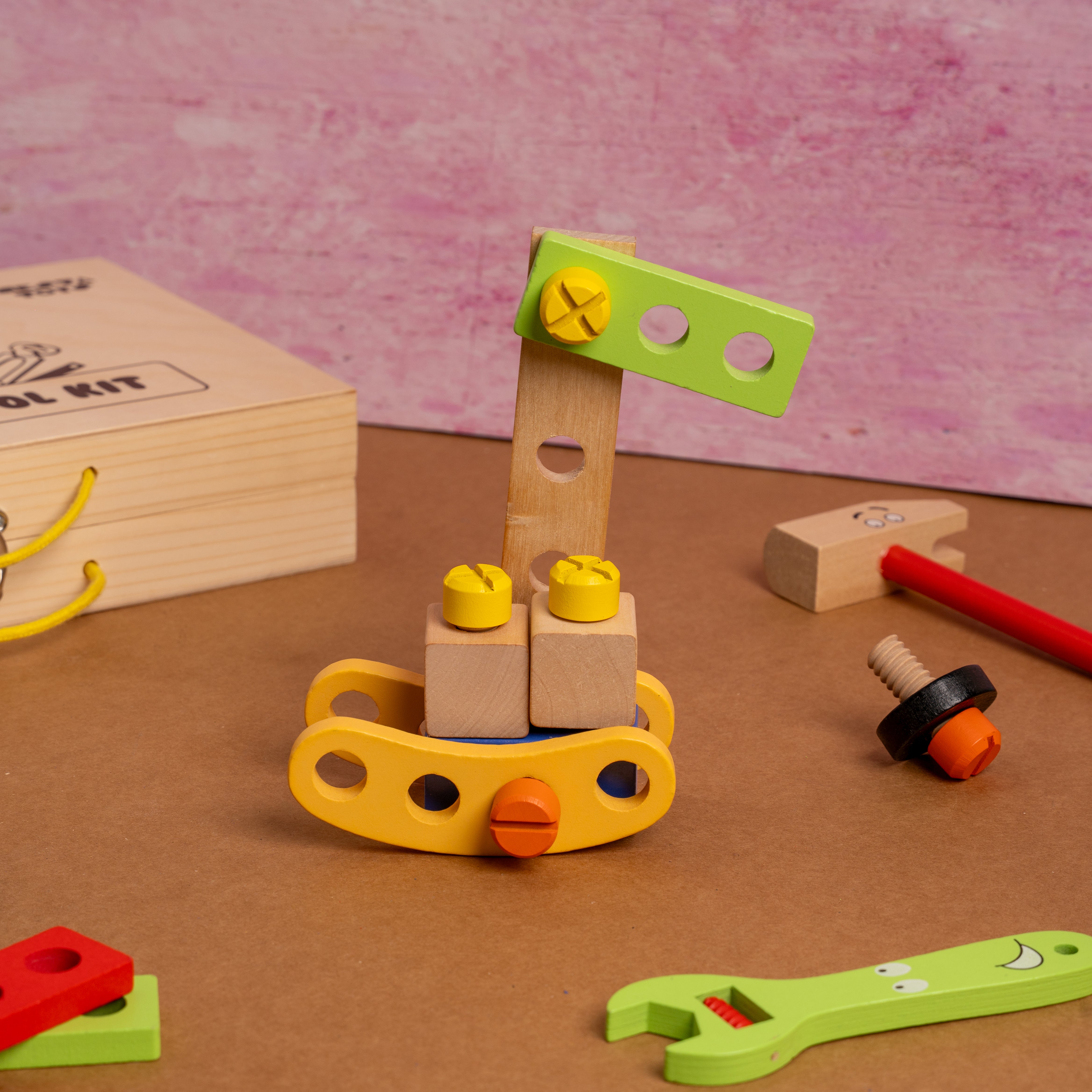  NESTA TOYS – Wooden Workbench Tool Kit Toy for Kids Children's toy tool set with wooden blocks and colorful tools on a brown surface.