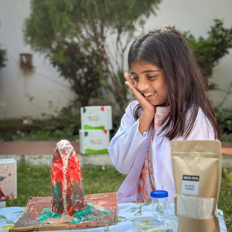 Child building and erupting a volcano model using the Nesta Toys kit